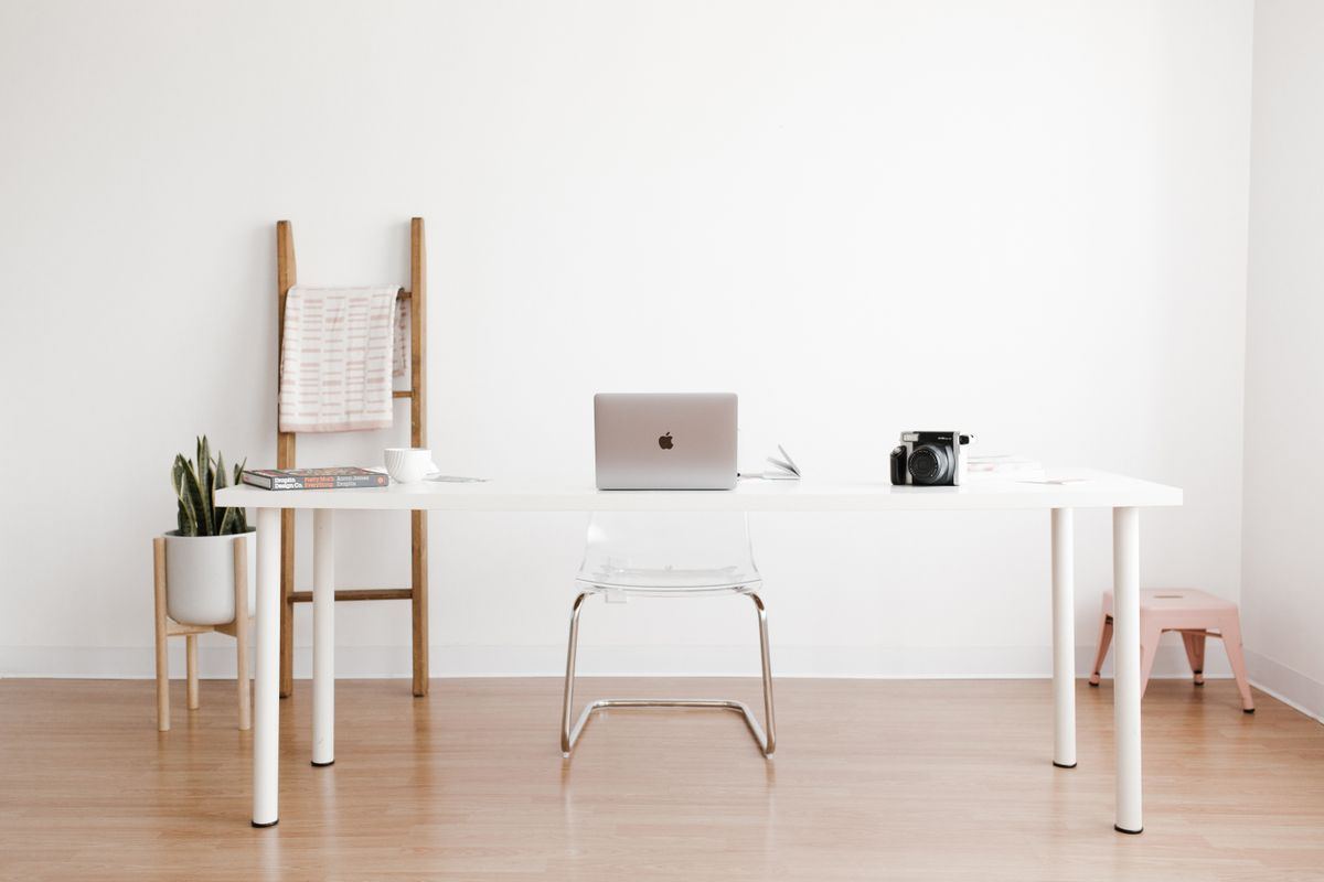 Minimal white desk and chair in a bright small room